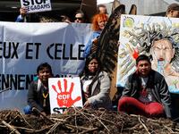 Members of indigenous tribes from the Amazon demonstrate alongside activists of 'Extinction Rebellion' (XR) against large hydroelectric dams in front of the Grande Arche de La Defense in Puteaux, northwest of Paris, on May 14, 2019. FRANCOIS GUILLOT / AFP