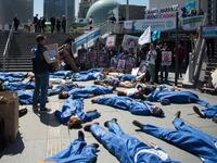 Activists of 'Extinction Rebellion' (XR) and NGO 'Planete Amazone' lie on the ground to stage an action called "die-in" to highlight the risk of the human race becoming extinct as a result of climate change, during a protest against large hydroelectric dams in front of the Grande Arche de La Defense, in Puteaux, northwest of Paris, on May 14, 2019. AFP