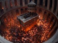 Christian Orthodox worshippers hold up candles lit from the ‘Holy Fire’ as they gather in the Church of the Holy Sepulchre in Jerusalem’s Old City on April 27, 2019. THOMAS COEX / AFP