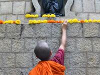 A young Buddhist monk decorates a stupa with flowers during "Vesak" or Buddha Purnima to commemorate the 2,563rd birth anniversary of the Buddha, at the Maha Bodhi Society in Bangalore on May 18, 2019. MANJUNATH KIRAN / AFP
