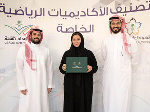 Lina Khaled Almaeena, center, the co-founder of Jeddah United Sports Co. (JUSC), receives a certificate from an official of the General Sports Authority.