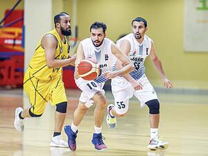 Al-Jahra player (left), shoots as Al-Sahel players defend during the Group 1 competitions of the Kuwait Basketball League Championship 2020-2021 season. (Photo: Arab Times)