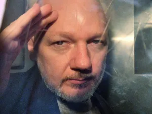 WikiLeaks founder Julian Assange gestures from the window of a prison van as he is driven out of Southwark Crown Court in London. (AFP/ File Photo)