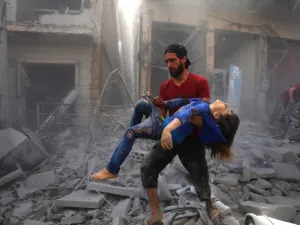 A man evacuates a young bombing casualty after a reported air strike by regime forces and their allies in the jihadist-held Syrian town of Maaret Al-Noman in the southern Idlib province, on May 26, 2019. (Abdulaziz KETAZ / AFP)