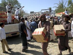 Yemenis carry boxes of food aid provided by the UAE Red Crescent for displaced people in the city of Marib. (Abdullah Al Qadry / AFP)