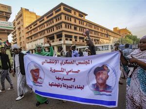 Sudanese supporters of the ruling Transitional Military Council (TMC) march with a banner showing the portraits of council chief General Abdel Fattah al-Burhan (R) and General Mohamed Hamdan Dagalo "Hamidati" (L). (AFP/ File)