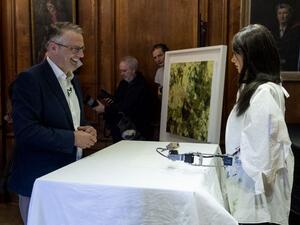 Gallery owner and creator Aidan Meller (L) talks to Ai-Da the AI humanoid robot artist (R) as it draws a portrait of him during a demonstration at a launch event for its first solo exhibition in Oxford on June 5, 2019. (Niklas HALLE'N / AFP)