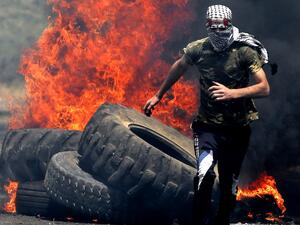 A Palestinian protester runs for cover while being chased by Israeli security forces during a weekly demonstration against the expropriation of Palestinian lands by Israel in the village of Kfar Qaddum, near Nablus in the occupied West Bank on June 7, 2019. (JAAFAR ASHTIYEH / AFP)