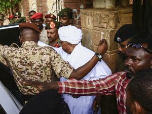 Sudan's ousted president Omar al-Bashir (C) is escorted into a vehicle as he returns to prison following his appearance before prosecutors over charges of corruption and illegal possession of foreign currency, in the capital Khartoum on June 16, 2019.  (AFP/ File Photo)