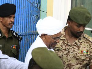 Ousted Sudanese leader Omar al-Bashir is escorted before being driven in an armed convoy from the Kober prison to the prosecutor's office in North Khartoum on June 16, 2019.  (AFP/ File Photo)
