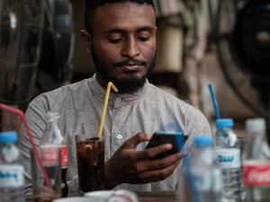 Sudanese Mohamed Omar, 25, uses his smart phone to access the internet a cafe in which an hour of internet costs 50 Sudanese pounds, which is approximately one US dollar, on June 17, 2019. (AFP/ File Photo)