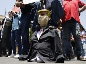 Palestinian demonstrators step on an effigy of US President Donald Trump during a protest against the US-sponsored Middle East economic conference that opens today in Bahrain, in the Israeli-occupied West Bank city of Nablus on June 25, 2019. (AFP/ File Photo) Palestinian demonstrators step on an effigy of US President Donald Trump during a protest against the US-sponsored Middle East economic conference that opens today in Bahrain, in the Israeli-occupied West Bank city of Nablus on June 25, 2019. (AFP/ File Photo)