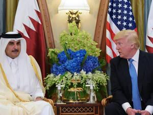 US President Donald Trump (R) speaks with Qatar's Emir Sheikh Tamim Bin Hamad Al-Thani, during a bilateral meeting at a hotel in the Saudi capital Riyadh.(AFP Photo)