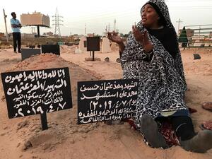 Khadom, the mother of Al-Moez visits the tomb of her son, killed when a bullet pierced the window of his workplace and lodged itself in his heart during an anti-government demonstration in the Sudanese capital Khartoum in April, on July 9, 2019. (AFP/ File Photo)