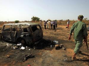 Libyans inspect the site of a car bomb attack that targeted servicemen during the funeral of an ex-army commander in the Libyan city of Benghazi (AFP)