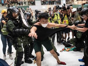 Police officers tear the shirt of a protester during a clash inside a shopping arcade in Sha Tin of Hong Kong after a rally against a controversial extradition law proposal in Sha Tin district of Hong Kong on July 14, 2019. (AFP/ File Photo)