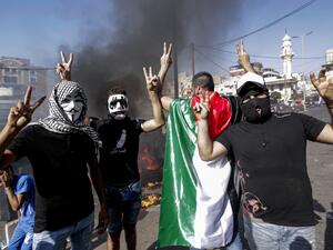 Masked protesters flash the victory gesture as they block the main road outside the Palestinian refugee camp of Burj al-Barajneh, south of the Lebanese capital Beirut, on July 16, 2019. (AFP/ File Photo)