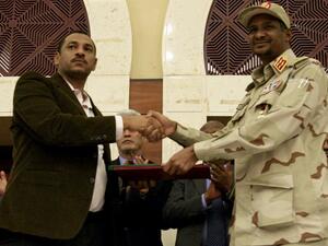 Sudanese deputy chief of the ruling miliary council Mohamed Hamdan Dagalo (R) and protest movement Alliance for Freedom and Changes leader Ahmad al-Rabiah shake hands after inking an agreement before African Union and Ethiopian mediators in Khartoum early on July 17, 2019. (AFP/ File Photo)