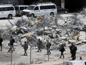 West Bank village of Dar Salah shows Israeli security forces walking past the rubble of a house that underwent a demolition in the area of Sur Baher in East Jerusalem (AFP)