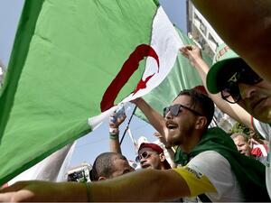 A man waves an Algerian national flag as protesters demonstrate in Algiers  (AFP)