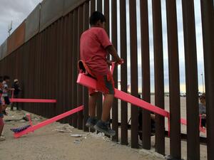American and Mexican families play with a toy called "up and down" (seesaw swing) over the Mexican border with US at the Anapra zone in Ciudad Juarez, Chihuahua State, Mexico. (AFP/ File Photo)