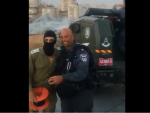 Israeli soldiers and police cheer the demolition of scores of Palestinian homes. (Twitter/ Screenshot)