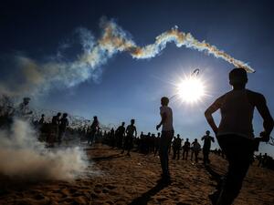 Palestinian youngsters use slingshots to hurl rocks at Israeli troops during clashes between Palestinian protesters and Israeli forces  (AFP)