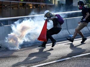 A protester preparing to cover a tear gas canister fired by the police with a traffic cone in the Admiralty district of Hong Kong during a general strike, as simultaneous rallies were held across seven districts.  (AFP/ File Photo)
