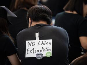 A protester wears a note on the back of his T-shirt as he takes part in a rally against a controversial extradition bill at Hong Kong's international airport (AFP)