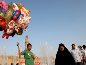 An Iraqi Kurdish man sells balloons on the central square near the citadel of Arbil, the capital of the autonomous Kurdish region of northern Iraq, as people celebrate the Muslim religious festival of Eid al-Adha on August 13, 2019. (AFP/ File Photo)