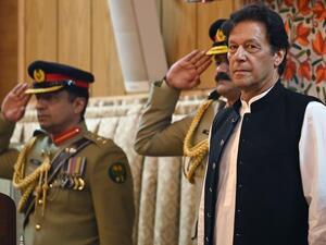 Pakistan's Prime Minister Imran Khan (R) listens to the national anthem as he arrives at the legislative assembly in Muzaffarabad. (AFP/ File Photo)