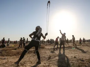 A Palestinian protester uses a slingshot to hurl stones during clashes with Israeli forces near the fence along the border with Israel in the eastern Gaza Strip on August 16, 2019.  (MAHMUD HAMS / AFP)