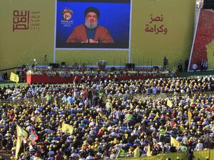 Hasan Nasrallah, the head of Lebanon's militant Shiite movement Hezbollah, delivers a speech on a screen during a commemoration marking the 13th anniversary of the end of the 2006 war with Israel in the southern Lebanese town of Bint Jbeil on August 16, 2019. (AFP)