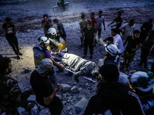 Members of the Syrian Civil Defence, also known as the "White Helmets", carry away on a stretcher a man rescued from the rubble of a collapsed building following a reported air strike in Kfar Ruma in Syria's northwestern Idlib province, on August 16, 2019. (AFP)