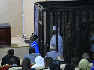 Sudan's deposed military ruler Omar al-Bashir stands in a defendant's cage during the opening of his corruption trial in Khartoum on August 19, 2019.  (AFP/ File Photo)