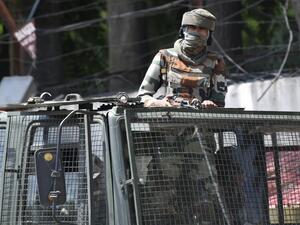 Indian army soldier stands alert in a truck while travelling in a convoy in Srinagar (AFP)