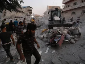 Members of the Syrian Civil Defence (White Helmets) clear debris during their search for survivors following a reported airstrike