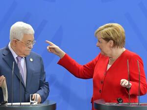 German Chancellor Angela Merkel points the way to Palestinian President Mahmud Abbas after a making a press statement before talks in Berlin on August 29, 2019.  Tobias SCHWARZ / AFP