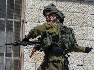 An Israeli soldier throws a stun grenade during clashes (AFP)