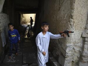 Afghan children play with plastic toy guns (AFP)
