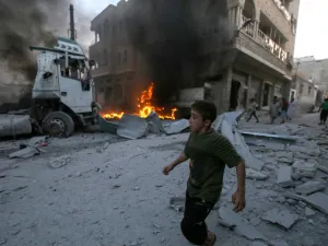 A young boy runs past a fire started in a building following a reported airstrike by Syrian regime forces in the town of Maaret al-Numan in Syria's northwestern Idlib province on August 28, 2019. (AFP/ File Photo)