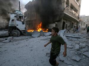 A young boy runs past a fire started in a building following a reported airstrike by Syrian regime forces in the town of Maaret al-Numan in Syria's northwestern Idlib province on August 28, 2019. (AFP/ File Photo)