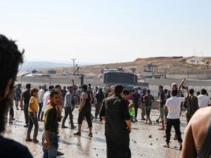 Displaced Syrians demonstrate along the border with Turkey near the town of Atme in the northwestern Idlib province (AFP)