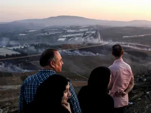 People watch as fires blaze along the Lebanese side of the border with Israel in the Lebanese village of Maroun al-Ras (AFP)