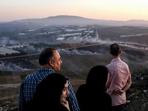 People watch as fires blaze along the Lebanese side of the border with Israel in the Lebanese village of Maroun al-Ras (AFP)