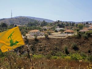 A Hezbolla flag flutters in the Khiyam plain on the Lebanese side of the border with Israel   (AFP)