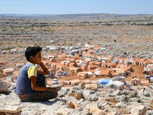 A young Syrian boy who was displaced from the town of Khan Sheikhoun, gazes from a small hilltop on September 8, 2019. (AFP/ File Photo)