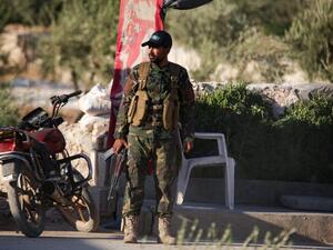 A Turkish-backed Syrian fighter stands guard on the outskirts of Syria's northern town (AFP)