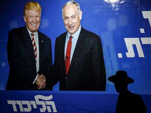 An Ultra-Orthodox Jewish man walks beneath an Israeli election billboard for the Likud party showing US President Donald Trump shaking hands with Likud chairman and Prime Minister Benjamin Netanyahu in Jerusalem on September 9, 2019. (AHMAD GHARABLI / AFP)