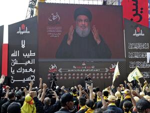 Supporters of the Lebanese Shiite Hezbollah movement react to a speech by their leader Hassan Nasrallah, transmitted or a large screen during a religious mourning procession on the tenth day of the lunar month of Muharram, which marks the day of Ashura, in a suburb of the capital Beirut, on September 10, 2019. (AFP/ File Photo)